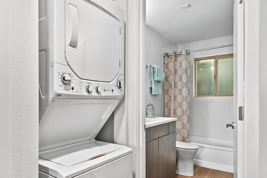 view of stacking washer and dryer by the bathroom